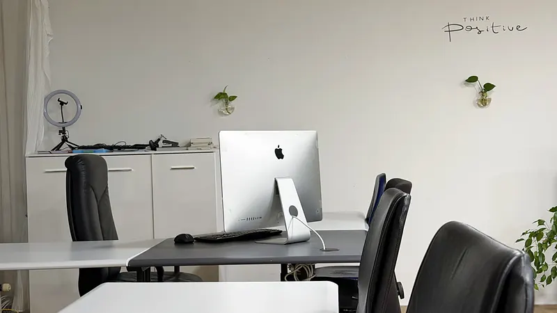 Workstation with iMac and Think positive wall motto at Webzenz Switzerland